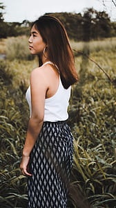 selective focus photo of woman standing surrounded by grass thumbnail