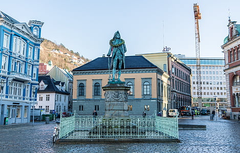 man wearing coat statue in the middle of square plaza thumbnail
