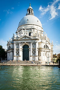 white concrete cathedral beside body of water thumbnail