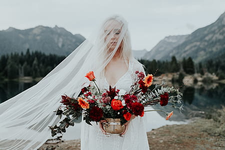 woman wearing a bridal gown holding a pot of flowers thumbnail