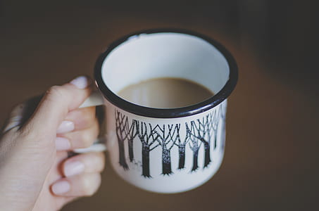 person holding white and black mug thumbnail