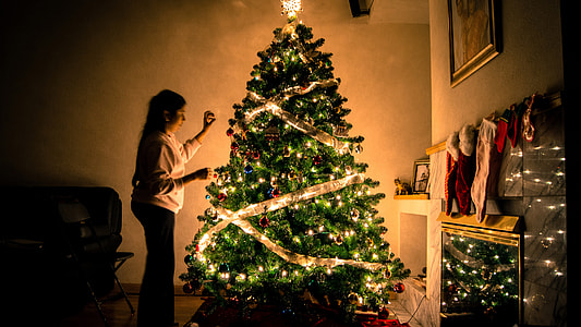 Woman decorating Ornamented Christmas Tree thumbnail