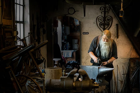 blacksmith man holding sledge hammer on anvil thumbnail