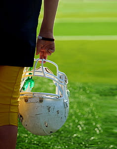 photo of person carrying white football helmet thumbnail