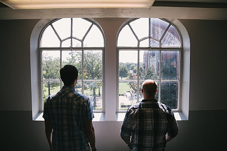 two men standing in front of clear glass windows during daytime thumbnail