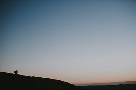 person on mountain under white sky thumbnail