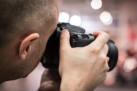 person using black DSLR camera in shallow focus photographty thumbnail