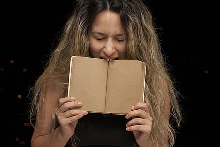 woman biting a brown book thumbnail