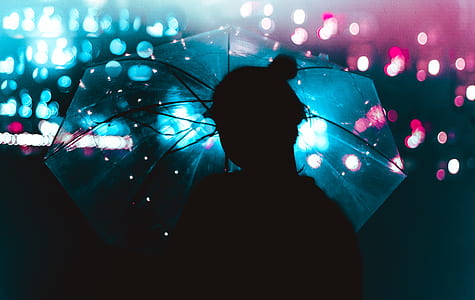 bokeh silhouette photography of woman using translucent umbrella thumbnail
