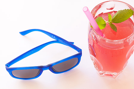 blue framed Wayfarer-style sunglasses near glass cup with juice drink thumbnail