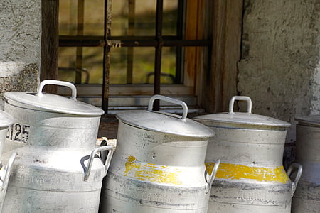 three gray milk churns on window thumbnail