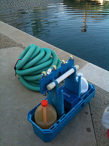 green hose beside blue rack near pool thumbnail