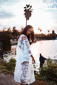 woman standing near body of water at daytime thumbnail