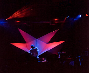 man standing on stage with red LED lights during night time thumbnail