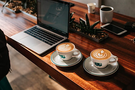 white cup and saucer beside laptop thumbnail