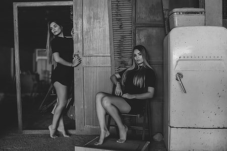 greyscale photography of woman sitting on folding chair thumbnail