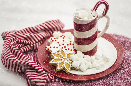 white and red ceramic mug on saucer with cookies thumbnail