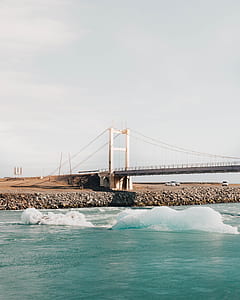ice floating on water near bridge thumbnail