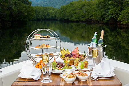 Food Photography of Food and Wine Bottles on Table Inside Boat thumbnail