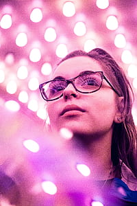 macro photography of woman in tortoiseshell framed eyeglasses under purple lights thumbnail