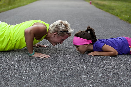 woman having a push-up in front of girl during daytime thumbnail