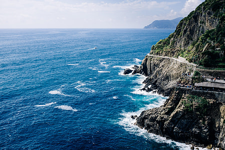 aerial photo of body of water and mountain under blue sky thumbnail