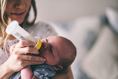 woman carrying baby and feeding using feeding bottle thumbnail