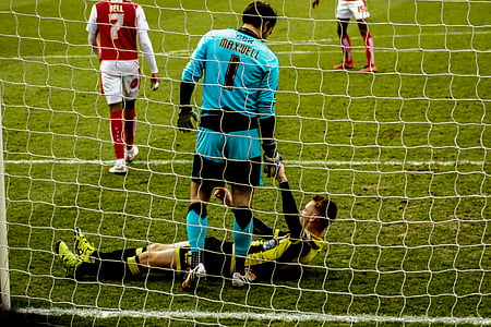 man reaching hand on another man while playing soccer game thumbnail