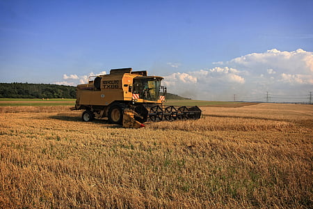 yellow automatic harvester on grass field thumbnail