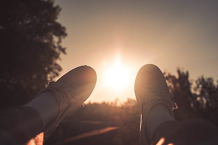 person taking photo of its white shoes during golden hour thumbnail