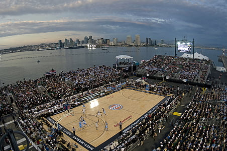 high angle photo of basketball game surrounded with mass of people near body of water during day thumbnail