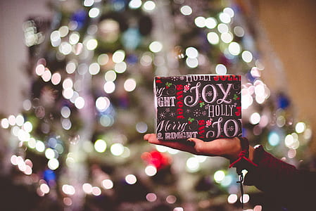 bokeh photography of person holding gift box thumbnail