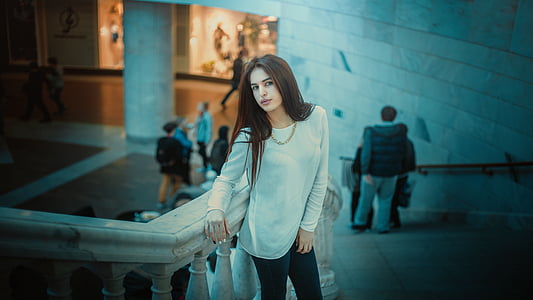 woman in white long-sleeved shirt leaning on concrete stair handrail thumbnail