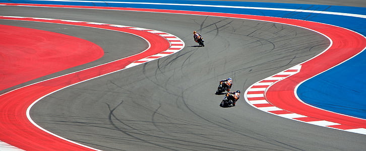 three people riding motorcycle and racing on field thumbnail