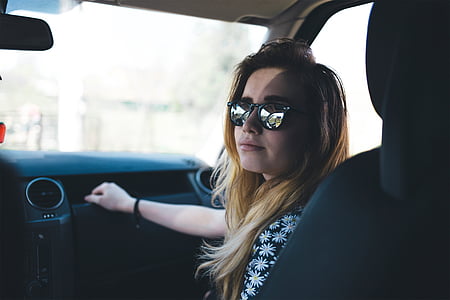 woman sitting inside vehicle while holding glove compartment and looking at the camera thumbnail