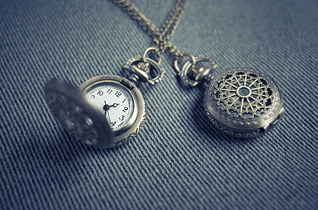 closeup photo of two silver-colored pocket watches on blue denim thumbnail