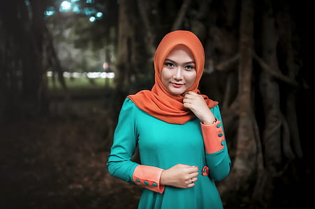 closeup photo of a woman wearing green long-sleeved dress holding her cheek thumbnail