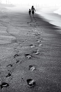 photo of boy and girl foot prints on sand thumbnail
