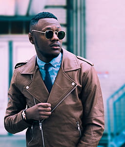 man wearing leather jacket and sunglasses rising his right arm thumbnail