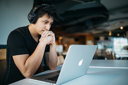 man wearing headphones sitting in front of MacBook thumbnail