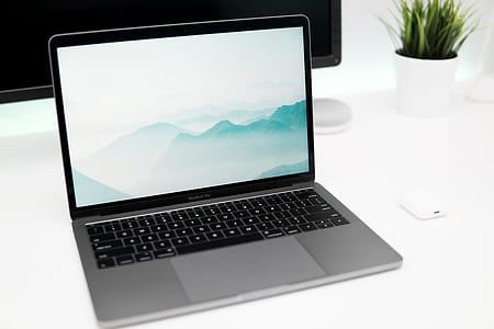 turned-on MacBook Pro with cloudy mountain wallpaper thumbnail
