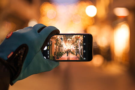 person wearing blue glove holding smartphone taking photo thumbnail