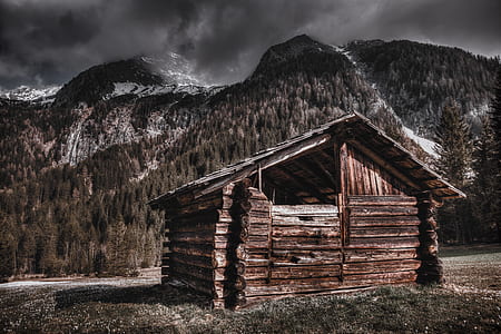 brown wooden house near mountain thumbnail