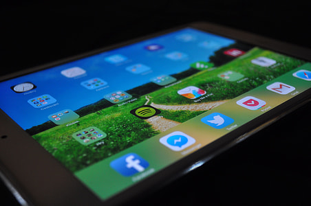 close-up photo of turned-on tablet computer showing green grass field wallpaper thumbnail