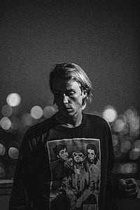 grayscale photo of man wearing Nirvana shirt thumbnail