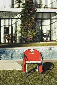 red long-sleeved shirt on armchair near pool thumbnail