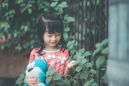 girl smiling holing plush toy and leaf thumbnail