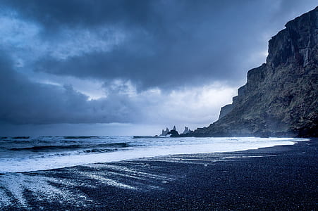 timelapse photography of splashing waves on seashore under cloudy sky thumbnail