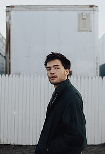 man standing near fence thumbnail
