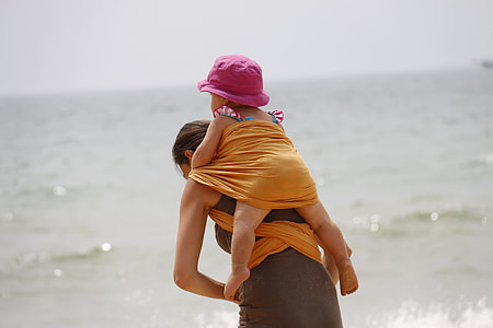 woman carrying child near seashore thumbnail